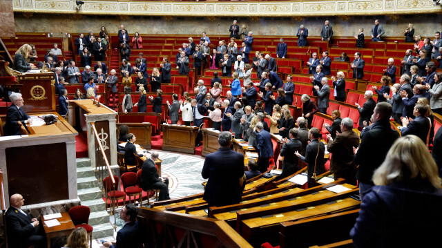 Les membres du Parlement applaudissent Hubert Wulfranc, député français du groupe "Gauche Démocrate et Républicaine" (GDR) et de la coalition de gauche NUPES, qui prend sa retraite, lors d'une session de questions au gouvernement à l'Assemblée nationale française à Paris le 20 décembre 2023.