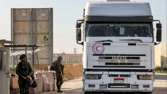 Un camion transportant de l'aide humanitaire du Croissant-Rouge égyptien passe devant des soldats israéliens au sud de la bande de Gaza, le 19 décembre 2023.