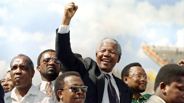Le président du Congrès national africain (ANC), Nelson Mandela, serreant le poing devant ses partisans à son arrivée à un meeting électoral, le 15 mars 1994 à Mmabatho. Le héros de la lutte contre l'apartheid, Nelson Mandela, est considéré comme une référence morale dans son pays, l'Afrique du Sud, mais dix ans après sa mort, son héritage fait l'objet de vifs débats, certains remettant en cause la qualité de la démocratie du pays.