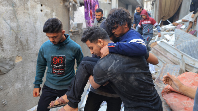 Un homme blessé est transporté après qu'une maison ait été touchée par un bombardement israélien à Khan Younes, dans le sud de la bande de Gaza, le 3 décembre 2023. Israël a procédé à des bombardements meurtriers dans la bande de Gaza le 3 décembre, alors que les appels internationaux se multiplient pour une meilleure protection des civils et le renouvellement d'une trêve expirée avec le groupe militant palestinien Hamas.