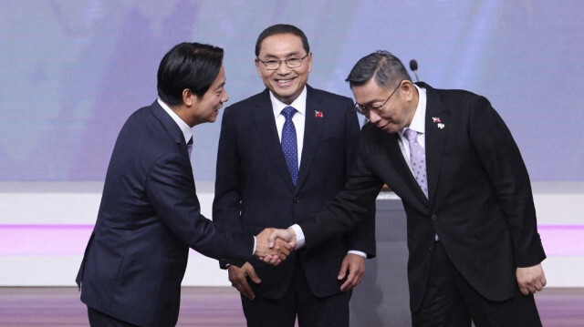 Lai Ching-te, candidat à la présidence du Parti démocrate progressiste (DPP), serre la main de Ko Wen-je, candidat à la présidence du Parti du peuple taïwanais (TPP), sous le regard de Hou Yu-ih (C), candidat à la présidence du principal parti d'opposition, le Kuomintang (KMT), lors d'un débat à Taipei le 30 décembre 2023.