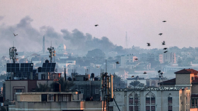 Une photo prise à Rafah montre de la fumée s'élevant au-dessus de Khan Yunis dans le sud de la bande de Gaza lors d'un bombardement israélien le 30 décembre 2023.