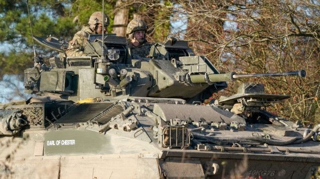 Le Prince William, Prince de Galles (à droite), en tant que colonel en chef du 1er bataillon du Mercian Regiment, à bord d'un véhicule blindé de combat Warrior lors d'une visite au régiment, près de Salisbury, dans le sud-ouest de l'Angleterre, le 23 novembre 2023.