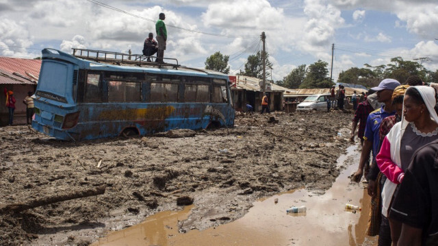Les habitants se rassemblent pour évaluer les dommages causés à une rue couverte de boue à la suite de glissements de terrain et d'inondations déclenchés par de fortes pluies à Katesh, en Tanzanie.