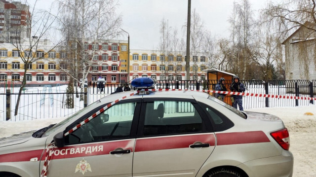 Des policiers russes montent la garde devant le gymnase numéro 5 suite à la fusillade, à Briansk, le 7 décembre 2023. 