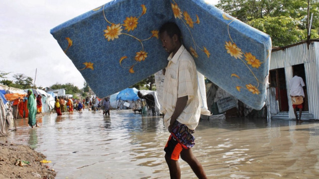 Un homme déplacé à l'intérieur de la Somalie transporte certaines de ses affaires à la suite de fortes pluies et d'inondations soudaines dans la capitale somalienne, Mogadiscio. 