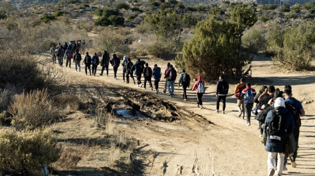 Des agents des services frontaliers inspectent des migrants entrés illégalement aux États-Unis le jour précédent avant de les emmener à un point d'entrée à Jacumba, en Californie, le 6 décembre 2023.