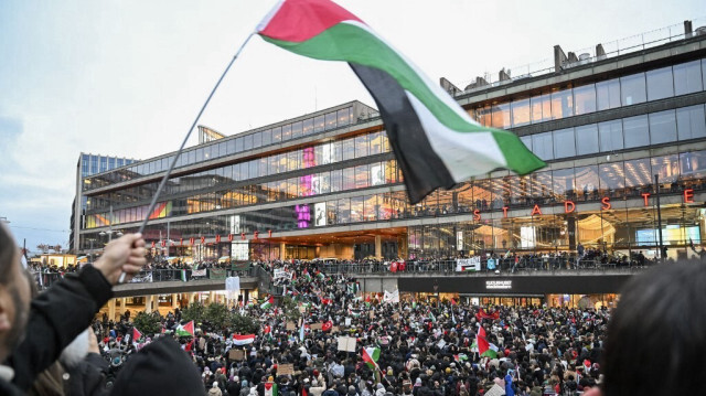 Des manifestants brandissent des drapeaux et des pancartes lors d'un rassemblement de solidarité avec les Palestiniens de la bande de Gaza, sur la place Sergel à Stockholm, en Suède, le 22 octobre 2023.