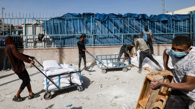 Des personnes tirant des chariots transportant des sacs d'aide humanitaire à distribuer aux Palestiniens, à Rafah, dans le sud de la bande de Gaza, le 26 novembre 2023. 