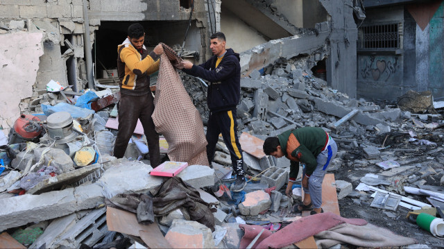 Des personnes récupèrant des objets après une frappe israélienne matinale à Rafah, dans le sud de la bande de Gaza, le 9 décembre 2023.