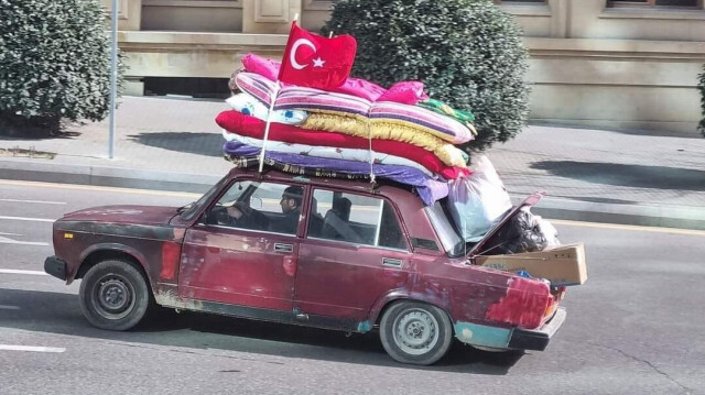 Sarvar Bashirli au volant de sa voiture avec un drapeau turc sur le toit, surchargée de matériel d'aide pour les personnes touchées par les séismes en Türkiye. Crédit photo: IHA