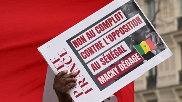 Un manifestant tient une pancarte qui dit "Non à la conspiration contre l'opposition au Sénégal" lors d'une manifestation contre le président sénégalais Macky Sall à Paris le 26 janvier 2023. Crédit Photo: Stefano Rellandini / AFP