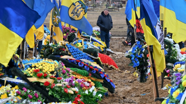 Un homme visite l'allée des héros dans un cimetière de Kharkiv, le 19 mars 2023, au milieu de l'invasion russe de l'Ukraine. Crédit Photo: Sergey BOBOK / AFP