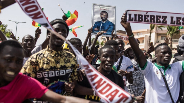 Des manifestants défilent dans les rues avec un portrait du chef de l'opposition, Ousmane Sonko. Crédit Photo: JOHN WESSELS / AFP