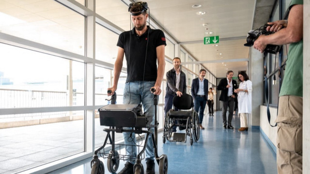 Gert-Jan des Pays-Bas, victime d'une lésion de la moelle épinière qui l'a laissé paralysé, marche avec ses implants lors d'une conférence de presse à Lausanne. Crédit photo: FABRICE COFFRINI / AFP