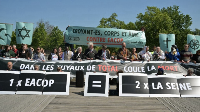 Une quarantaine de militants écologistes se sont enchaînés sur une passerelle à Paris, en France, pour protester contre les projets de TotalEnergies. Crédit photo: ALAIN JOCARD / AFP