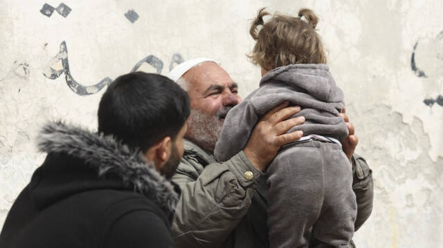 Ibrahim Osman jouant avec Hibatullah découverte abandonnée à la porte de la mosquée d'un village en Syrie. Crédit photo: OMAR HAJ KADOUR / AFP