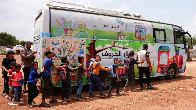 Un bus transformé en salle de classe itinérante pour accueillir des enfants sans abri et sans école dans un camp de personnes déplacées dans la province d'Alep en Syrie. Crédit photo: RAMI AL SAYED / AFP