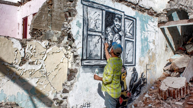 L'artiste de rue yéménite, Alaa Rubil, termine l'une de ses œuvres peintes sur un mur de la ville portuaire d'Aden au Yemen. Crédit photo: SALEH AL-OBEIDI / AFP