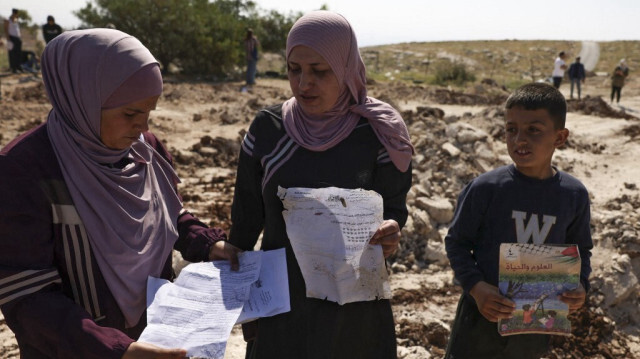 Des Palestiniens ramassent des papiers et des livres sur le site d'une école qui a été démolie par les autorités israéliennes en Cisjordanie. Crédit photo: HAZEM BADER / AFP