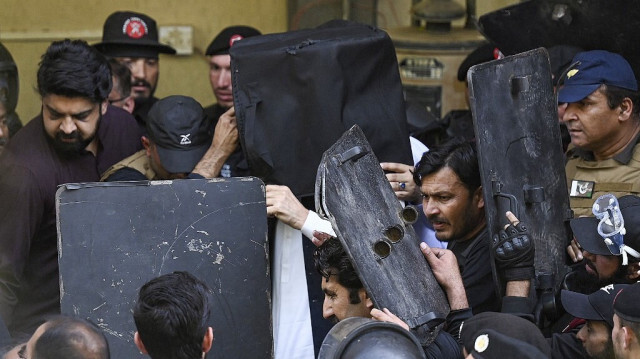 Le personnel de sécurité utilise des boucliers pare-balles pour protéger l'ancien Premier ministre pakistanais Imran Khan (C) à son arrivée à la Haute Cour d'Islamabad, le 27 mars 2023. Crédit photo: Aamir QURESHI / AFP