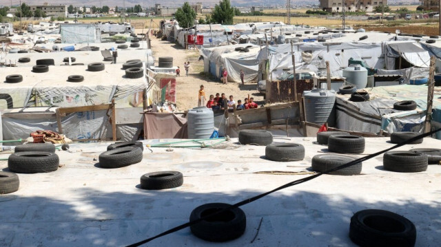 Les enfants syriens se rassemblent, entre les tentes du camp de réfugiés, dans la vallée de  Bekaa au Liban. Crédit photo: ANWAR AMRO / AFP