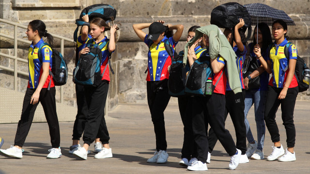 Un groupe de gymnastes vénézuéliens se protègeant du soleil pendant l'une des journées les plus chaudes de la troisième vague de chaleur à Guadalajara, dans l'État de Jalisco, au Mexique, le 12 juin 2023. Crédit Photo: ULISES RUIZ / AFP

