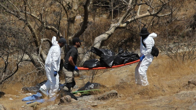 Les experts judiciaires inspectent les sacs de restes humains extraits du fond d'un ravin par un hélicoptère et abandonnés dans la communauté de Mirador Escondido à Zapopan, dans l'État de Jalisco, au Mexique, le 31 mai 2023. Crédit photo: ULISES RUIZ / AFP
