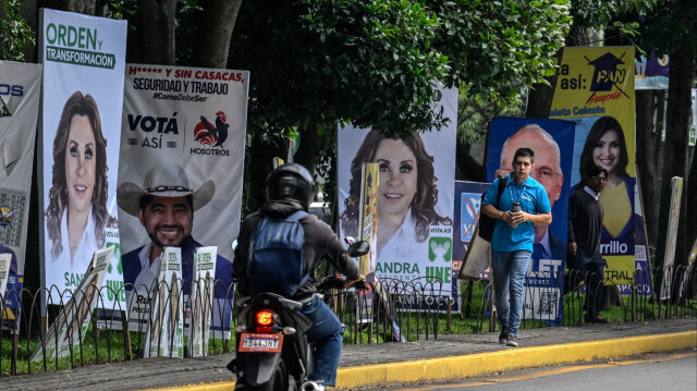 Des personnes passant devant les bannières des candidats aux élections générales à Guatemala City, le 22 juin 2023. Crédit Photo: Luis ACOSTA / AFP

