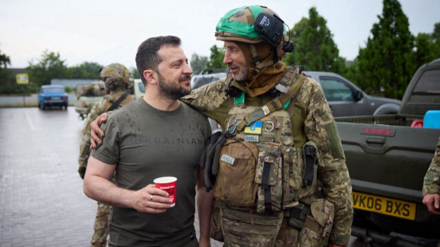 Le Président de l'Ukraine, Volodymyr Zelensky (G) pose avec un militaire dans une station-service lors d'une visite dans la région de Donetsk. Crédit photo: HANDOUT / UKRAINIAN PRESIDENTIAL PRESS SERVICE / AFP
