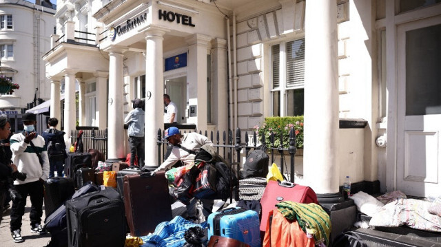 Un groupe de migrants avec leurs bagages manifestent dans l'ouest de Londres, le 2 juin 2023, pour se plaindre de leurs conditions de vie. Crédit Photo: HENRY NICHOLLS / AFP

