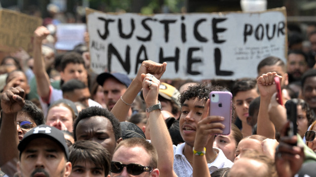 Des participants tenant une banderole sur laquelle on peut lire "Justice pour Nahel", lors de la marche blanche commémorative du 29 juin 2023. Crédit Photo: Bertrand GUAY / AFP

