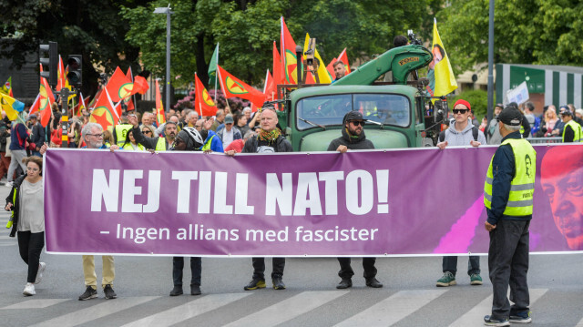 Les activistes du réseau "Alliance contre l'OTAN" tiennent une banderole sur laquelle on peut lire "Non à l'OTAN ! Pas d'alliance avec les fascistes" et portent des drapeaux avec le logo du PKK, l’organisation terroriste, contre l'adhésion de la Suède à l'OTAN, le 4 juin 2023 à Stockholm, Suède. Crédit photo: MAJA SUSLIN / TT NEWS AGENCY / AFP
