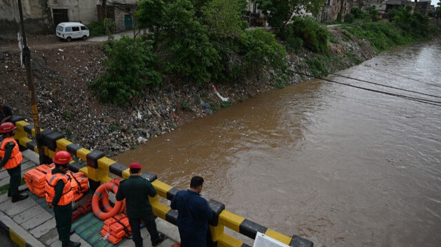 Des secouristes surveillant la situation des inondations sur un pont au-dessus d'un ruisseau à Rawalpindi le 7 juillet 2023. Crédit Photo: Aamir QURESHI / AFP

