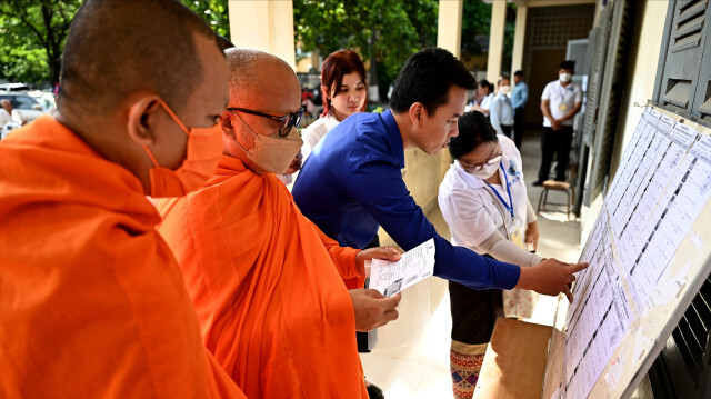 Des moines bouddhistes consultant les listes électorales dans un bureau de vote à Phnom Penh le 23 juillet 2023 lors des élections législatives. Crédit Photo: TANG CHHIN Sothy / AFP

