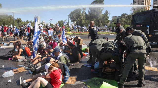 Des membres des forces de sécurité israéliennes évacuent des manifestants lors d'un sit-in visant à bloquer l'entrée du Parlement (Knesset) à Jérusalem. Crédit photo: RONALDO SCHEMIDT / AFP