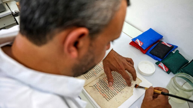 Le Palestinien Rami Salameh, restaurateur, travaille sur un manuscrit à la bibliothèque Khalidi, dans la vieille ville de Jérusalem. Crédit photo: AHMAD GHARABLI / AFP