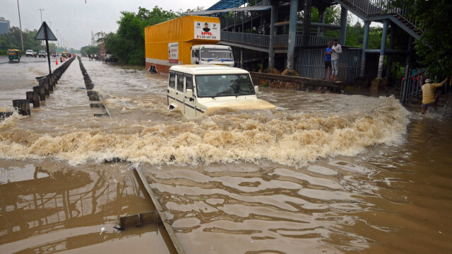 Un banlieusard conduisant sa voiture sur une autoroute inondée après de fortes pluies de mousson à Gurgaon, dans la banlieue de New Delhi, le 9 juillet 2023. Crédit Photo: AFP