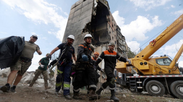 Des sauveteurs transportent le corps d'un habitant après que l'immeuble résidentiel de neuf étages a été partiellement détruit par une attaque de missiles russes à  Kryvyï Rih, le 31 juillet 2023. Crédit photo: ANATOLII STEPANOV / AFP
