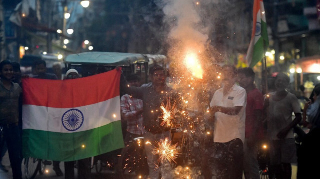 Des personnes brandissent le drapeau national pour célébrer l'alunissage réussi du vaisseau spatial Chandrayaan-3 en Inde. Crédit photo: SANJAY KANOJIA / AFP