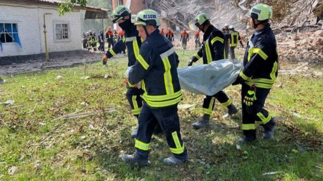 Des secouristes transportant le corps d'une victime hors de l'école dévastée, suite à l'attaque russe dans la ville de Romny, en Ukraine, le 23 août 2023. Crédit photo: HANDOUT / UKRAINIAN STATE EMERGENCY SERVICE / AFP
