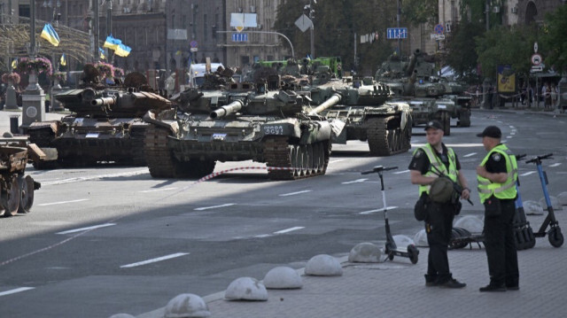 Des policiers se tiennent près des véhicules blindés russes détruits, exposés dans l'avenue Khreshchatyk de Kiev, le 22 août 2023, à la veille de la fête de l'indépendance de l'Ukraine. Crédit photo: GENYA SAVILOV / AFP
