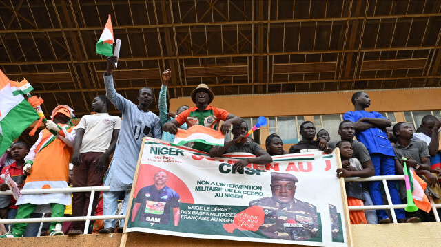 Des partisans du Conseil national pour la sauvegarde de la patrie (CNSP) du Niger tenant une banderole avec la photo du nouveau chef militaire du Niger, le général Abdourahamane Tiani, alors qu'ils se rassemblent au stade général Seyni Kountche à Niamey le 26 août 2023.  Crédit Photo: AFP