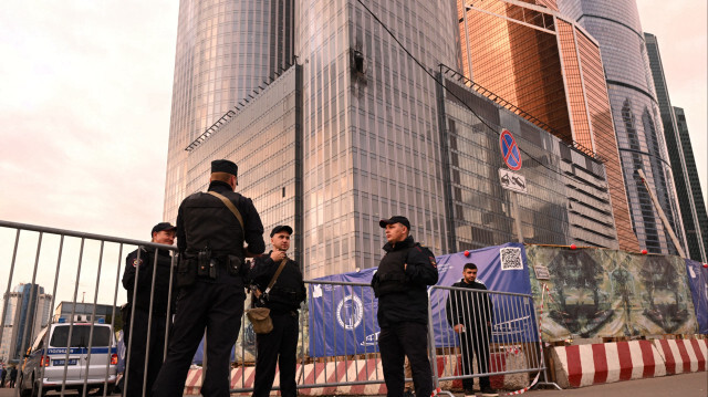 Des agents des forces de l'ordre se tiennent à côté d'un bâtiment endommagé du Centre d'affaires international de Moscou à la suite d'une attaque de drone. Crédit photo: NATALIA KOLESNIKOVA / AFP