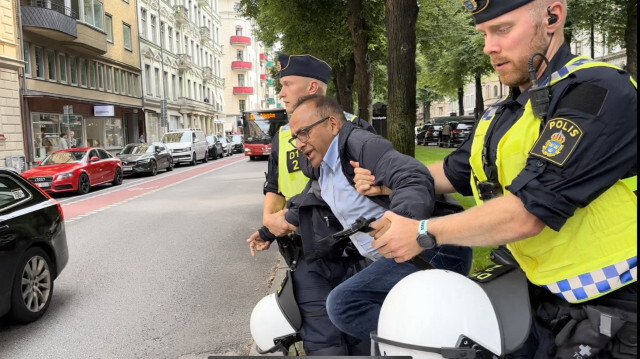 L'intervention de la police suédoise auprès de Malik Shahza, l'escortant hors de la zone dédiée à l'autodafé du Coran par Salwan Momika, un réfugié irakien installé en Suède. Crédit photo: AGENCE ANADOLU