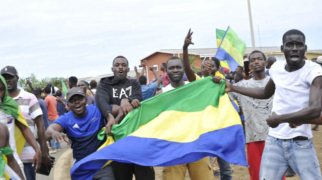 Des habitants faisant des gestes et brandissant le drapeau national du Gabon alors qu'ils célèbrent à Libreville le 30 août 2023, l'annulation des élections et la prise du pouvoir par les militaires. Crédit Photo: AFP