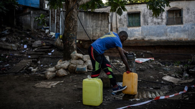 Un habitant remplissant des bidons d'eau potable à Mayotte. Crédit photo: PHILIPPE LOPEZ / AFP