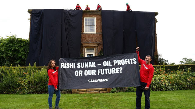İngiltere Başbakanı Rishi Sunak'ın Yorkshire'da bulunan malikanesinin çatısına tırmanan Greenpeace aktivistleri, binayı petrol siyahı kumaşla kapladı.