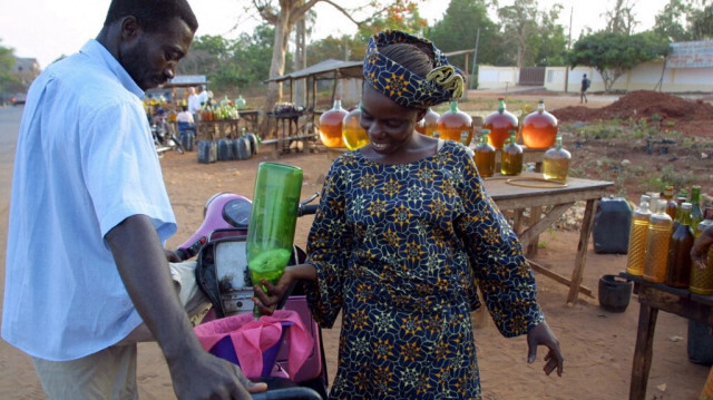 Une femme vend de l'essence de mauvaise qualité, appelée "kpayo". Crédit photo: ISSOUF SANOGO / AFP