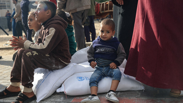 Des Palestiniens recevant des sacs de farine au centre de distribution de l'Office de secours et de travaux des Nations Unies pour les réfugiés de Palestine (UNRWA) dans le camp de réfugiés de Rafah, dans le sud de la bande de Gaza, le 21 novembre 2023.